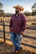 Rustline FR pearl snap work shirt worn with jeans and work boots at a ranch fence