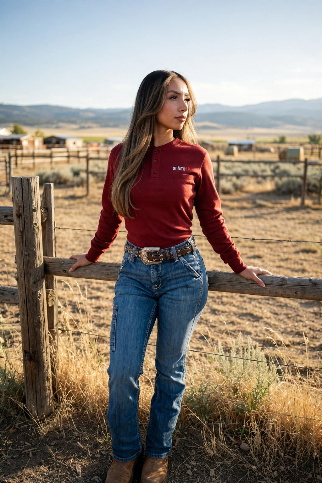 Wine Red Women's FR Henley worn with jeans and boots at a ranch fence